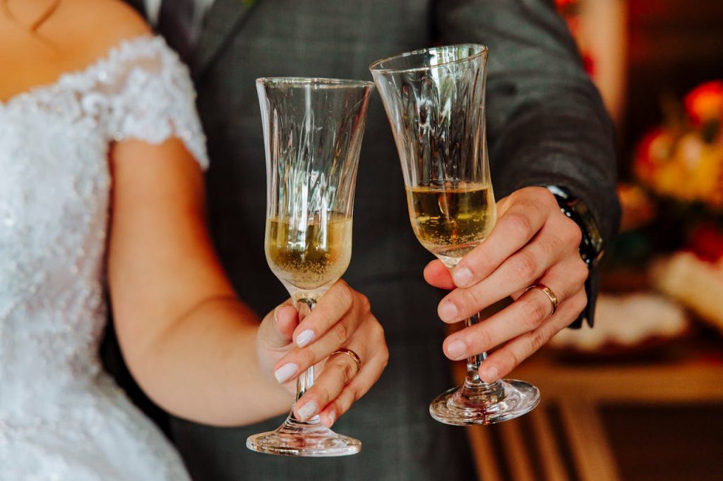 Feierlicher Hochzeitsmoment – Sektgläser beim Anstoßen Zwei Sektgläser stoßen bei einer Hochzeitsfeier an – festliche Stimmung und Feierlaune.